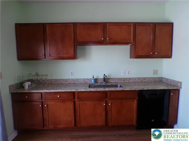 a kitchen with granite countertop wood cabinets and a sink