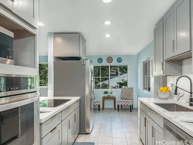 a kitchen that has a sink and chairs
