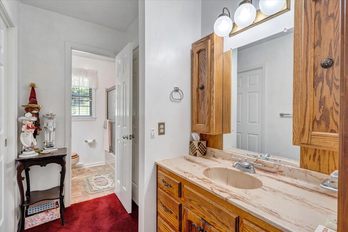 3737 Bore Auger Road Blue Ridge, VA 24064 - Photo 41 of 100 a bathroom with a granite countertop sink a mirror and a shower
