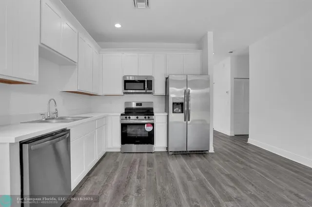 a kitchen with a refrigerator sink and cabinets