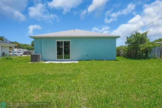 a view of a backyard with plants and large trees