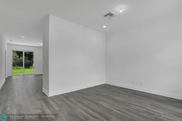 a view of a room with wooden floor and window
