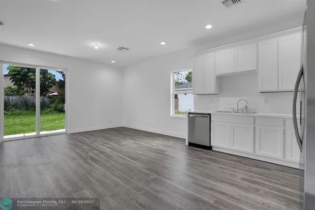 a kitchen with granite countertop a stove a sink and a refrigerator