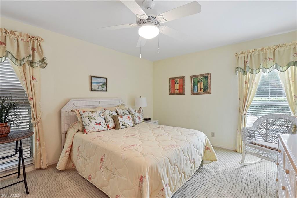 84 Georgetown Boulevard, Unit 84 Naples, FL 34112 - Photo 12 of 17 a bedroom with bed and a chandelier