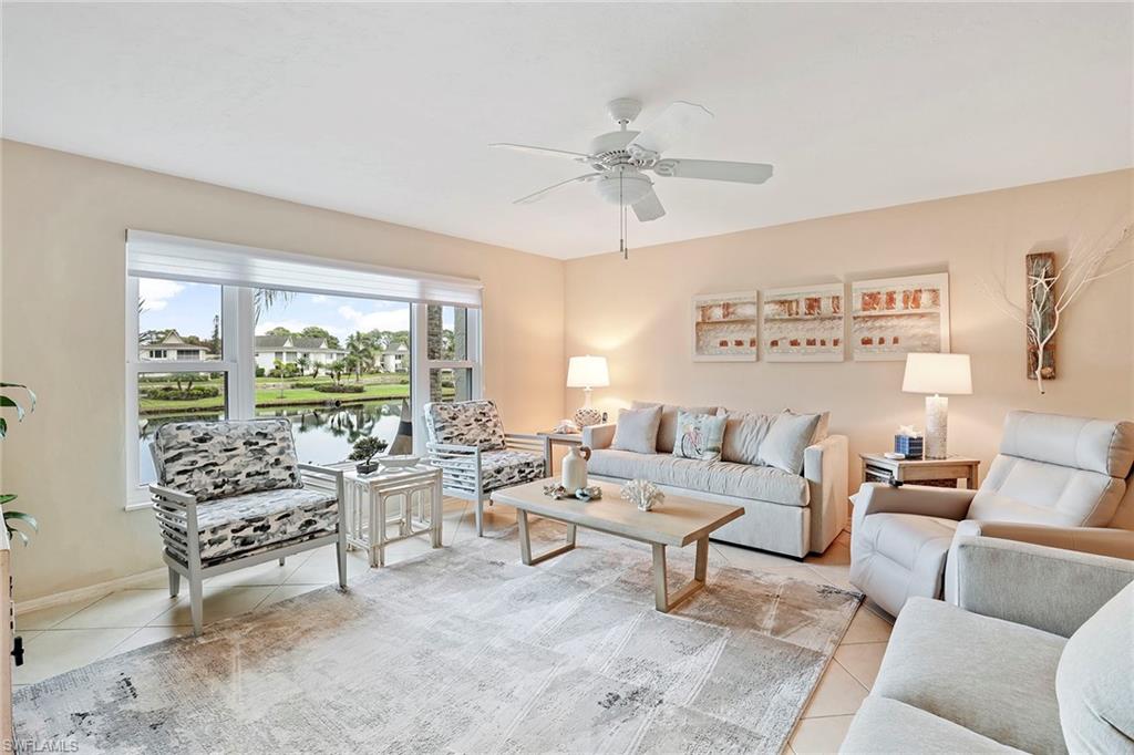 84 Georgetown Boulevard, Unit 84 Naples, FL 34112 - Photo 2 of 17 a living room with furniture and a large window