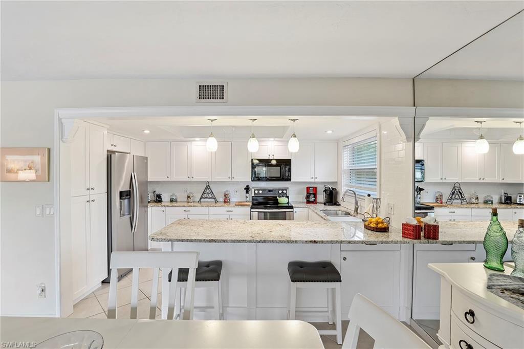 84 Georgetown Boulevard, Unit 84 Naples, FL 34112 - Photo 7 of 17 a kitchen with stainless steel appliances granite countertop a sink counter space and cabinets