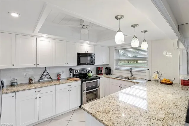 a kitchen with stainless steel appliances granite countertop a sink stove and white cabinets