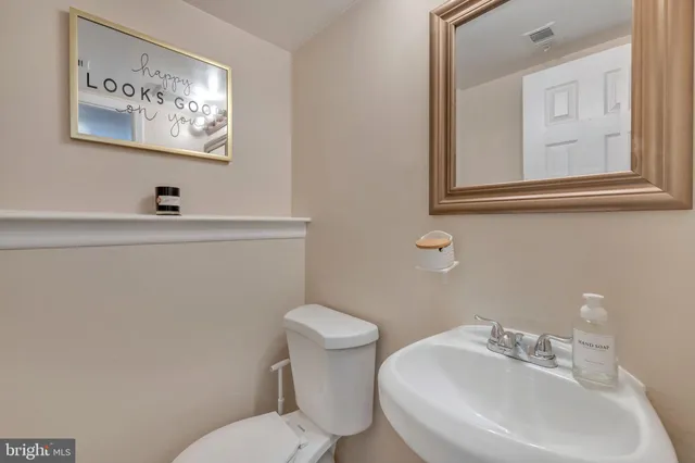 a bathroom with a toilet a sink and mirror