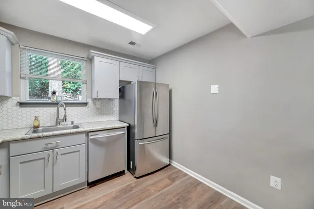 a kitchen with a refrigerator sink and cabinets