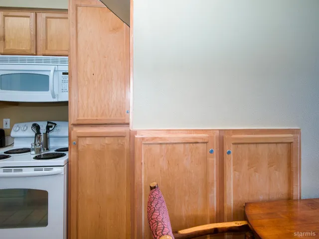 a view of a bedroom with wooden floor and furniture