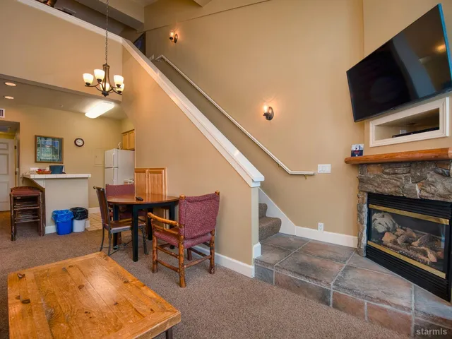 a living room with furniture a flat screen tv and kitchen view