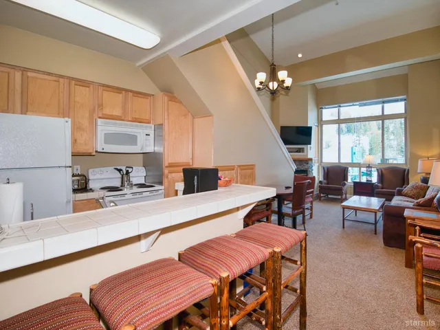 a living room with furniture a chandelier and a dining table