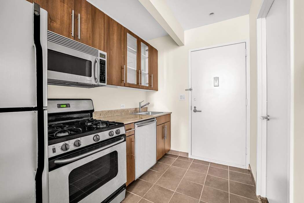 1 Wall Street Court, Unit PH08 Manhattan, NY 10005 - Photo 3 of 11 a kitchen with stove and cabinets