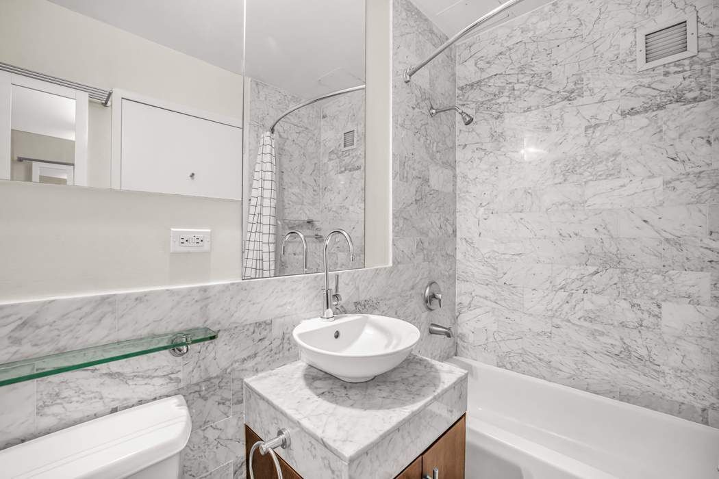 1 Wall Street Court, Unit PH08 Manhattan, NY 10005 - Photo 4 of 11 a bathroom with a sink toilet and shower