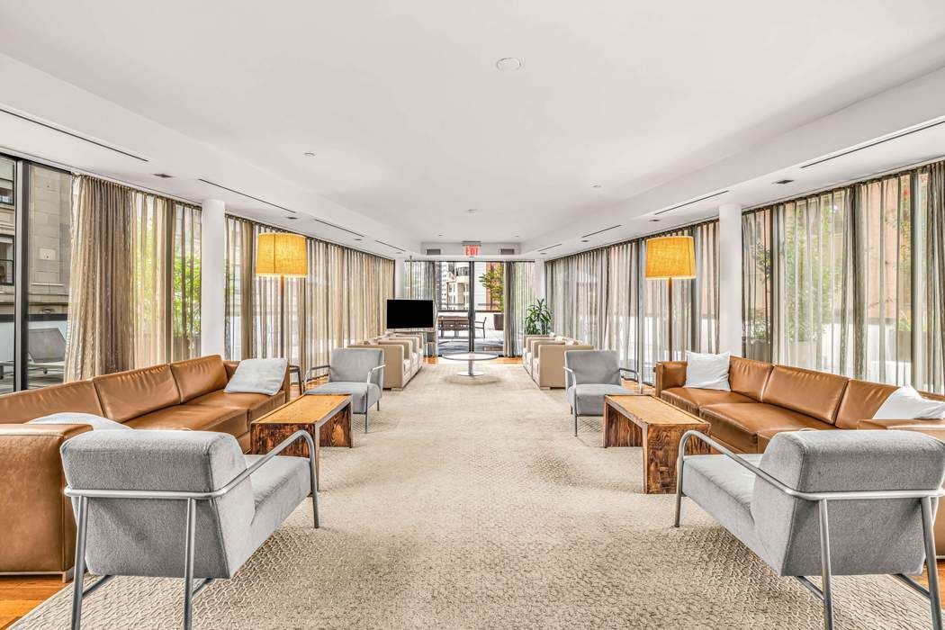 1 Wall Street Court, Unit PH08 Manhattan, NY 10005 - Photo 7 of 11 a living room with furniture and large windows