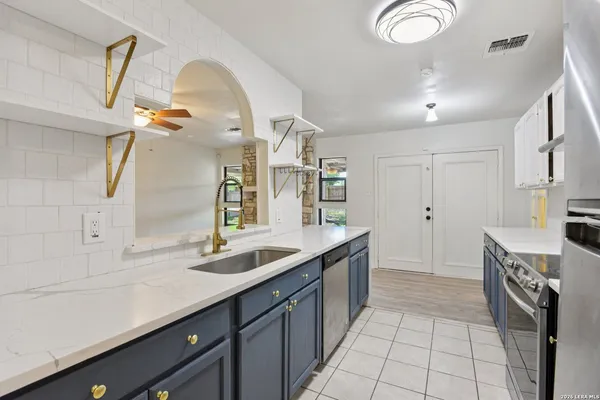 a kitchen with a sink dishwasher a stove and a refrigerator with wooden floor