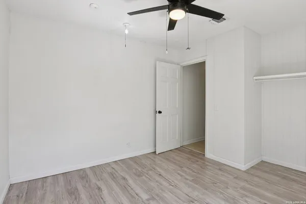 an empty room with a ceiling fan and a fan
