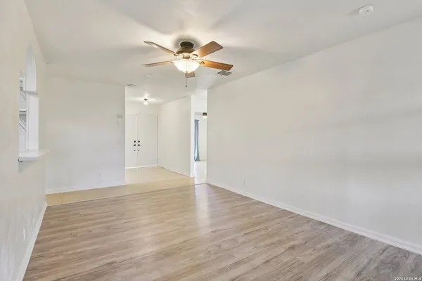 a view of an empty room with wooden floor