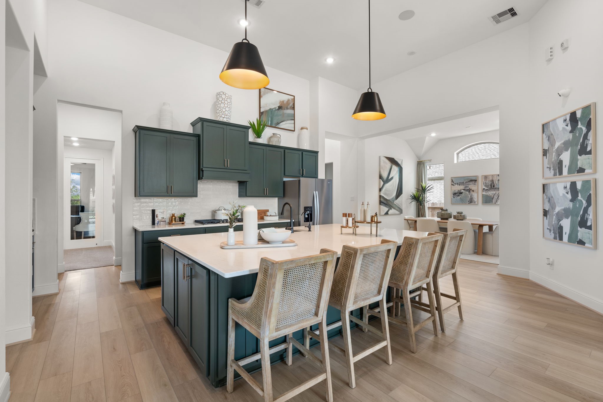 2318 Gleaming Pear Drive Manvel, TX 77578 - Photo 3 of 13 a kitchen with stainless steel appliances kitchen island granite countertop a table chairs and a refrigerator