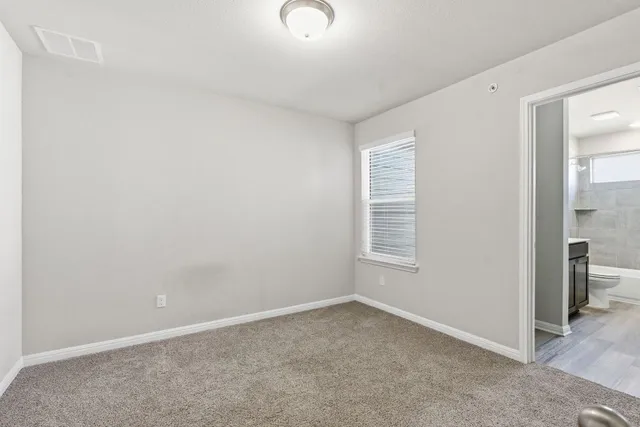 a spacious bedroom with a bed and a chandelier