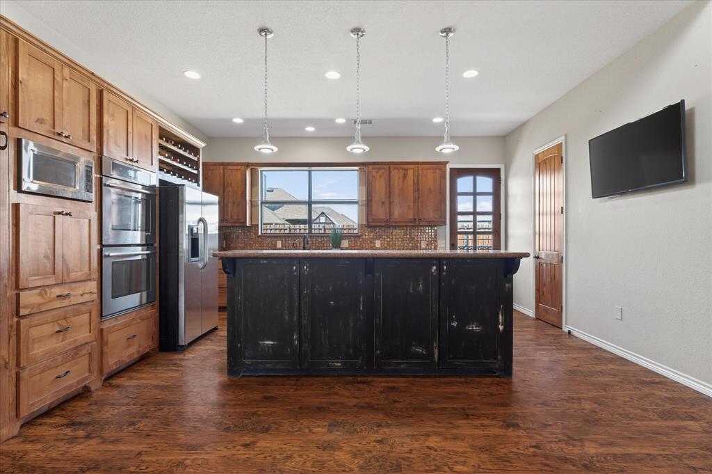 611 Mohawk Street Tioga, TX 76271 - Photo 10 of 37 Kitchen with breakfast bar, double ovens, built in microwave and two large pantries on either side.