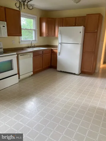 a kitchen with stainless steel appliances a stove a sink and a refrigerator
