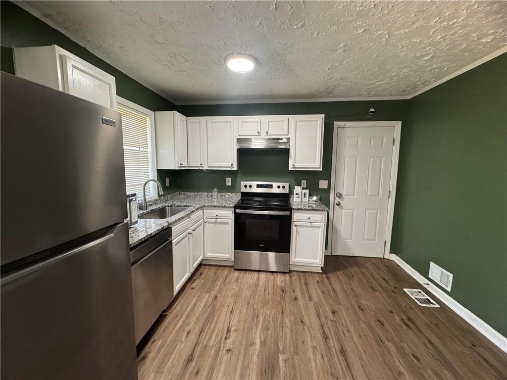2536 Butner Road Atlanta, GA 30331 - Photo 6 of 19 a kitchen with granite countertop a refrigerator and a stove top oven