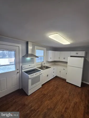 a view of a hallway with wooden floor and a fireplace