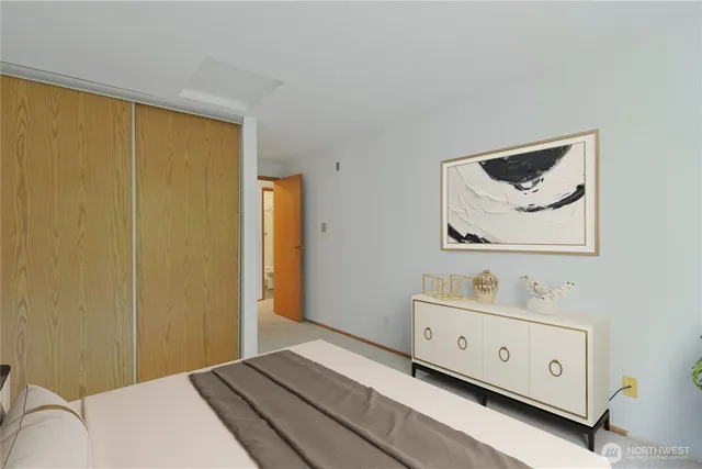 a bedroom with a bed and a lamp on dresser