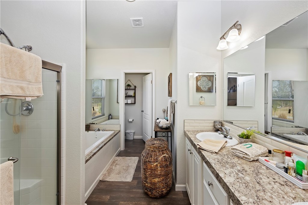 23161 Forrest Road Perris, CA 92570 - Photo 22 of 43 a spacious bathroom with a granite countertop sink a mirror a vanity and shower