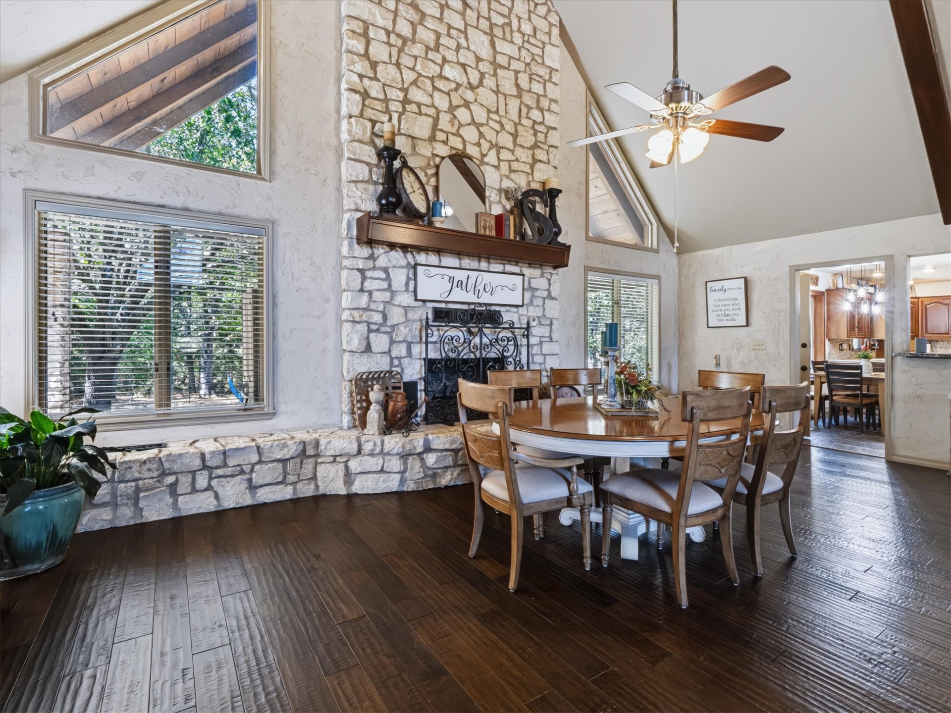 1133 West Chicken Fight Road Atoka, OK 74525 - Photo 11 of 49 Vaulted ceiling with exposed wood beams, stone fireplace with wood mantel, dark wood-finish flooring, and multiple windows