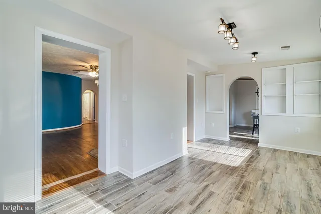 a view of a hallway with wooden floor and a livingroom view