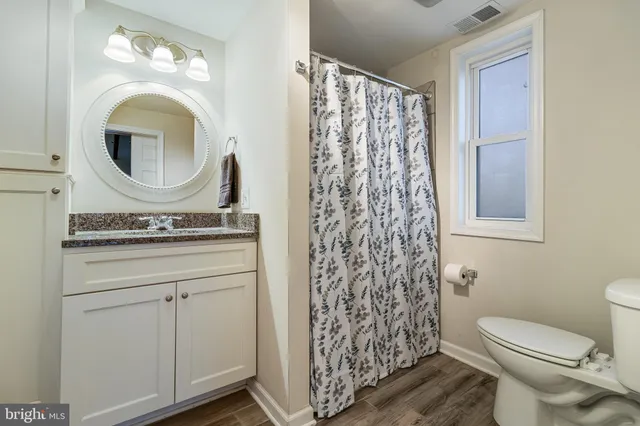 a bathroom with a toilet a sink and a mirror