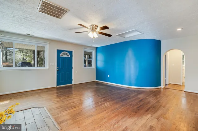 a view of an empty room with window and wooden floor