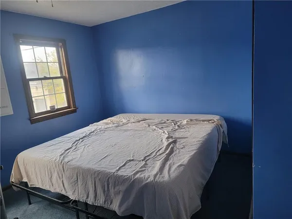 a bed sitting in a bedroom next to a window