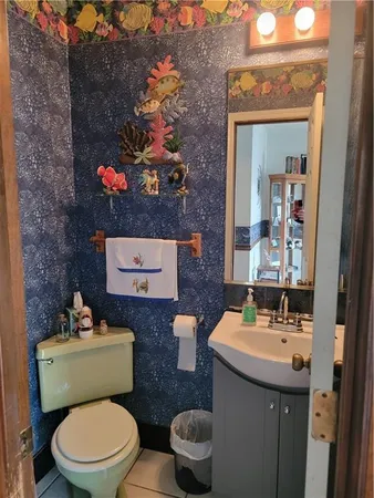 a bathroom with a toilet a sink and mirror