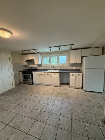a large kitchen with cabinets and stainless steel appliances