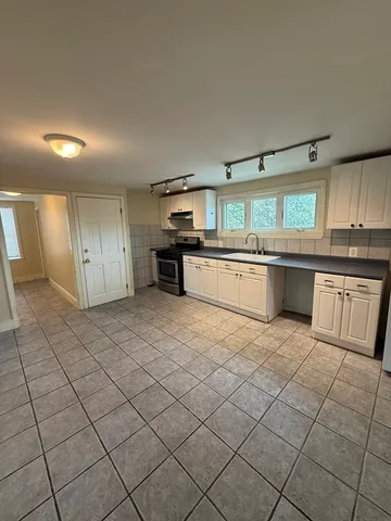 a large kitchen with a stove a sink dishwasher and a refrigerator