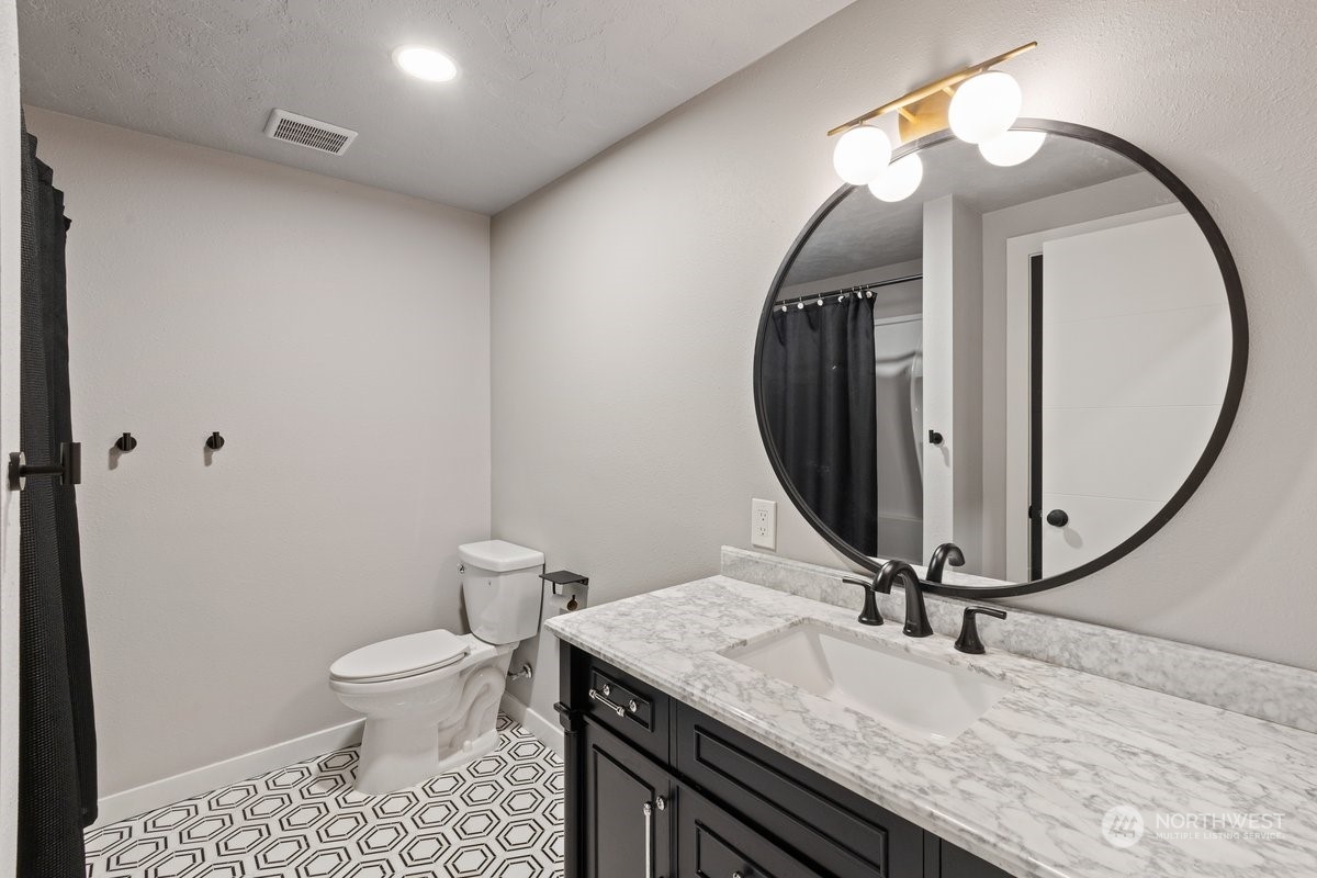 1835 Hood River Road Liberty Lake, WA 99016 - Photo 26 of 37 a bathroom with a granite countertop sink a toilet and a mirror