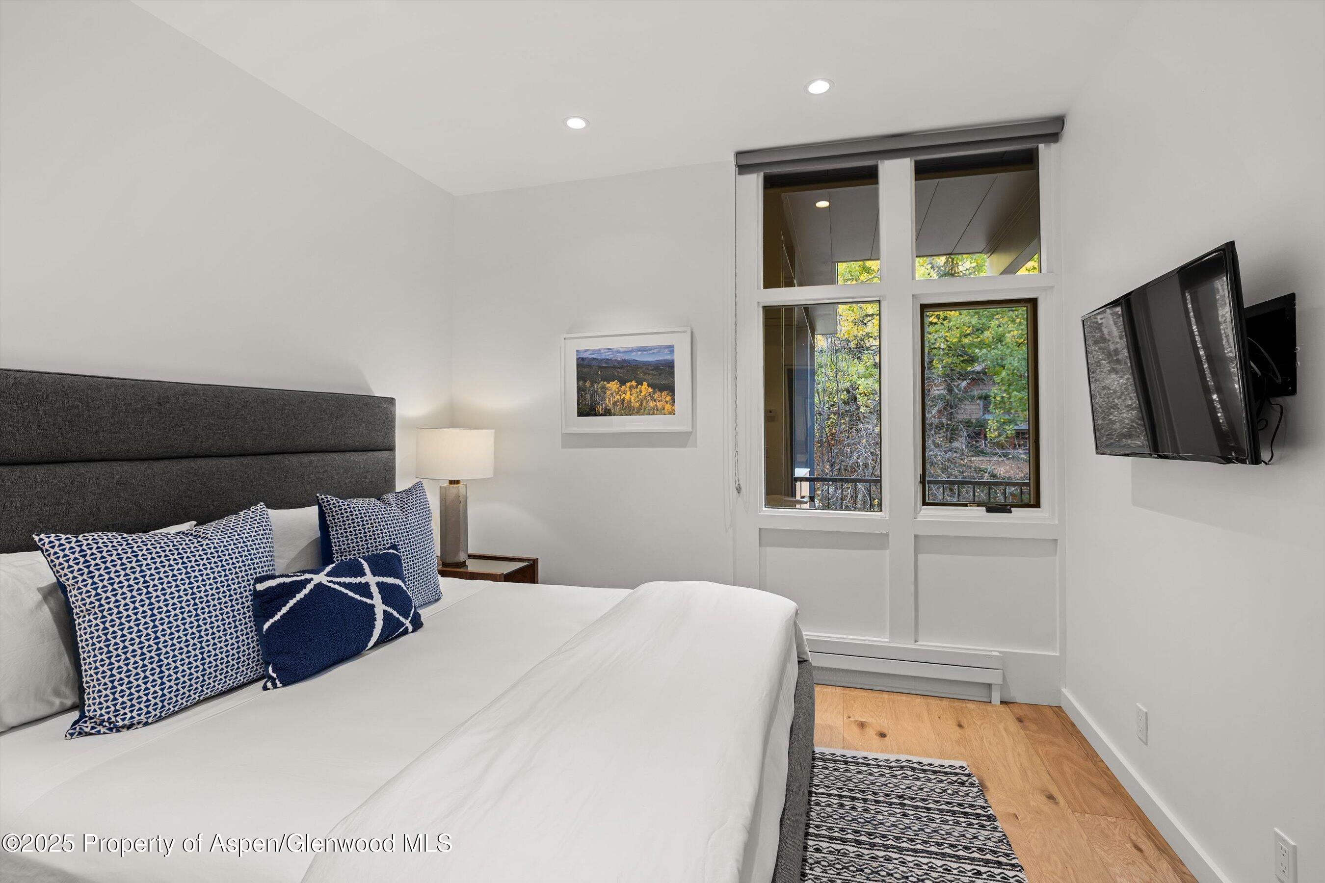 800 South Mill Street, Unit 303C Aspen, CO 81611 - Photo 11 of 32 a bedroom with a large bed and a window