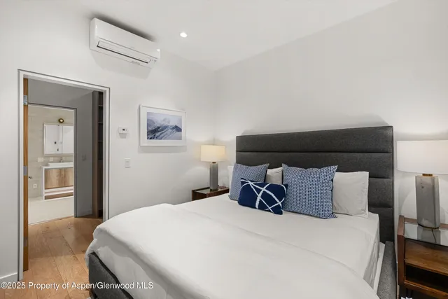 a bedroom with a bed and painting on the wall