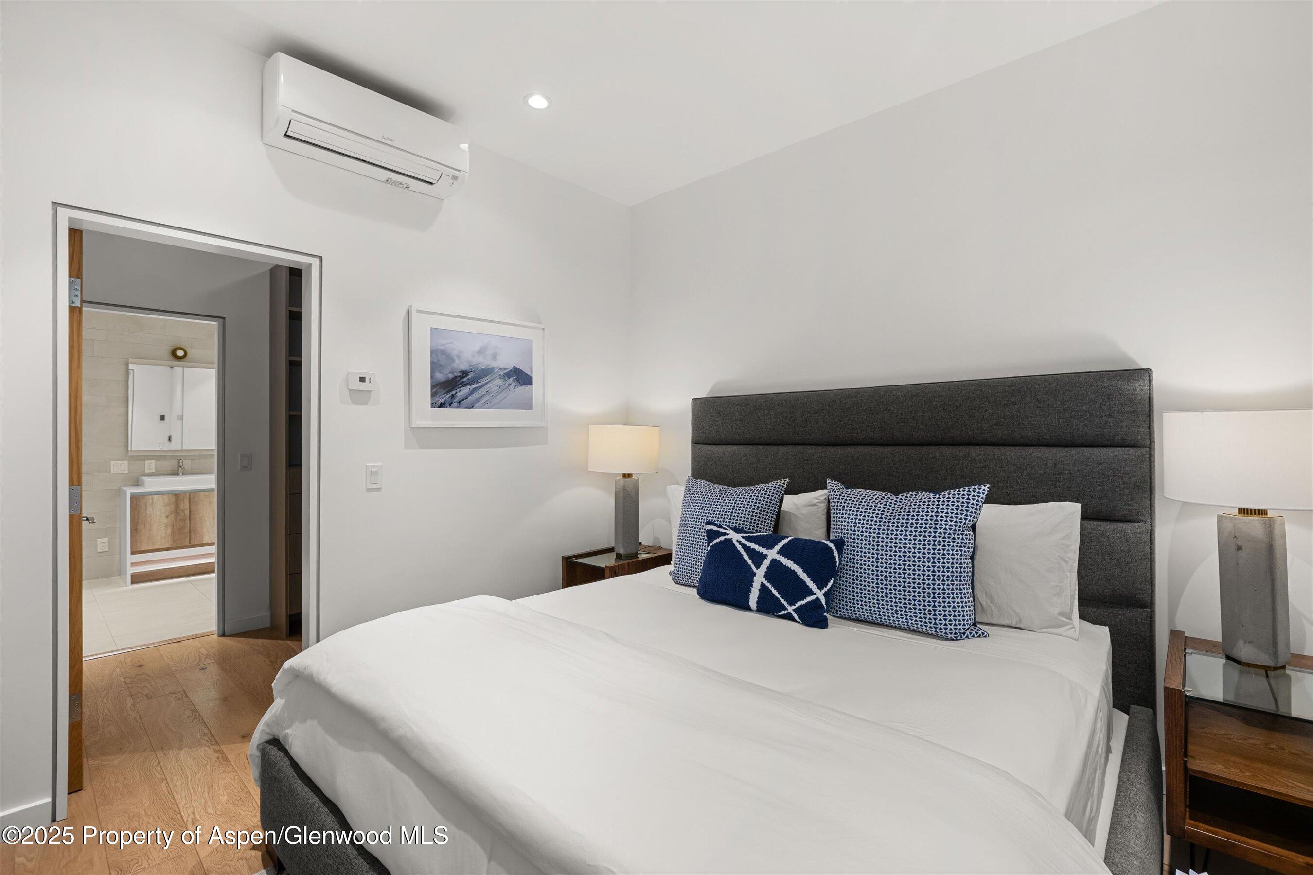 800 South Mill Street, Unit 303C Aspen, CO 81611 - Photo 14 of 32 a bedroom with a bed and painting on the wall