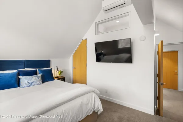 a bedroom with a bed and a flat screen tv