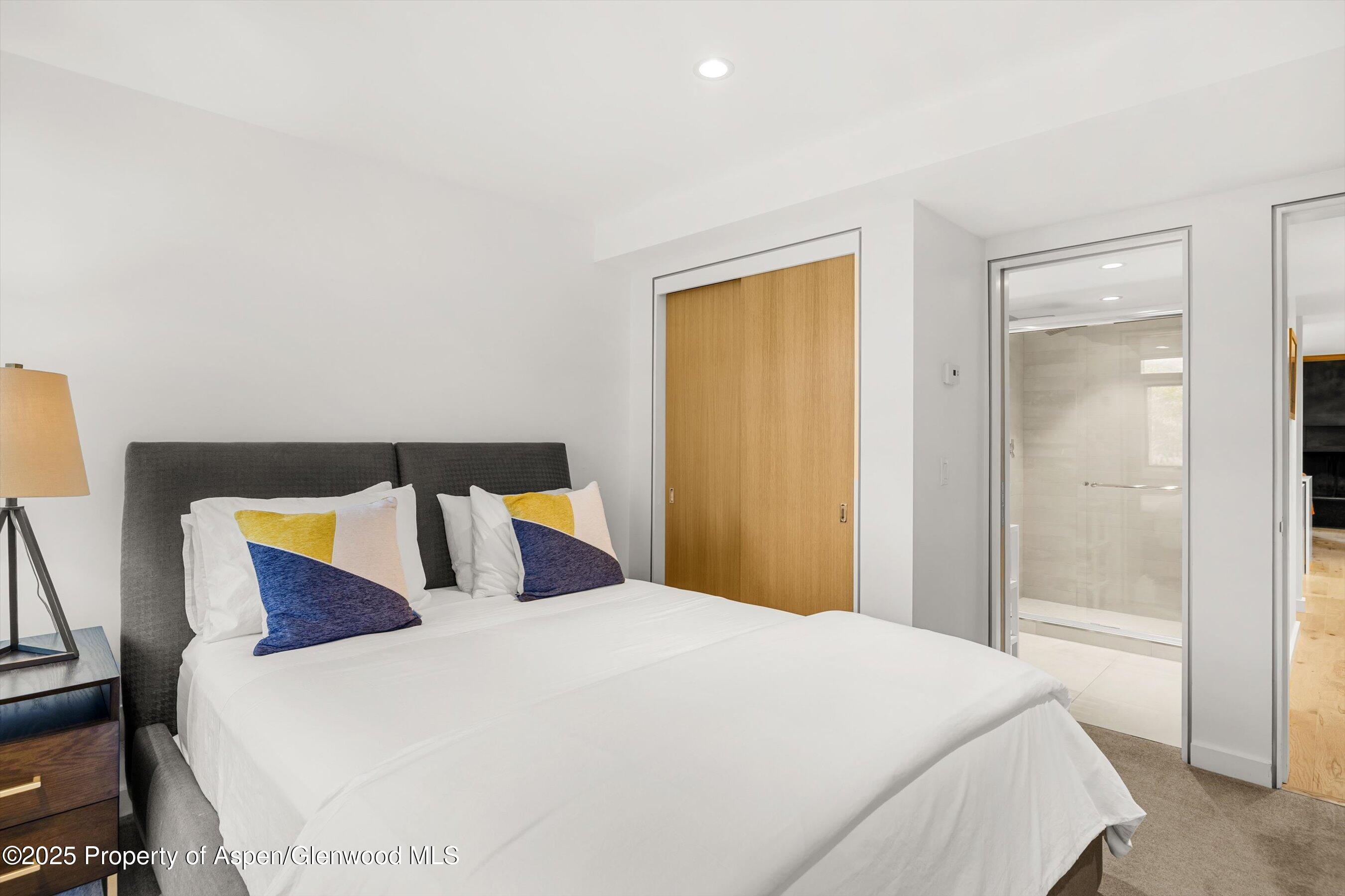 800 South Mill Street, Unit 303C Aspen, CO 81611 - Photo 24 of 32 a bedroom with a bed and a night stand