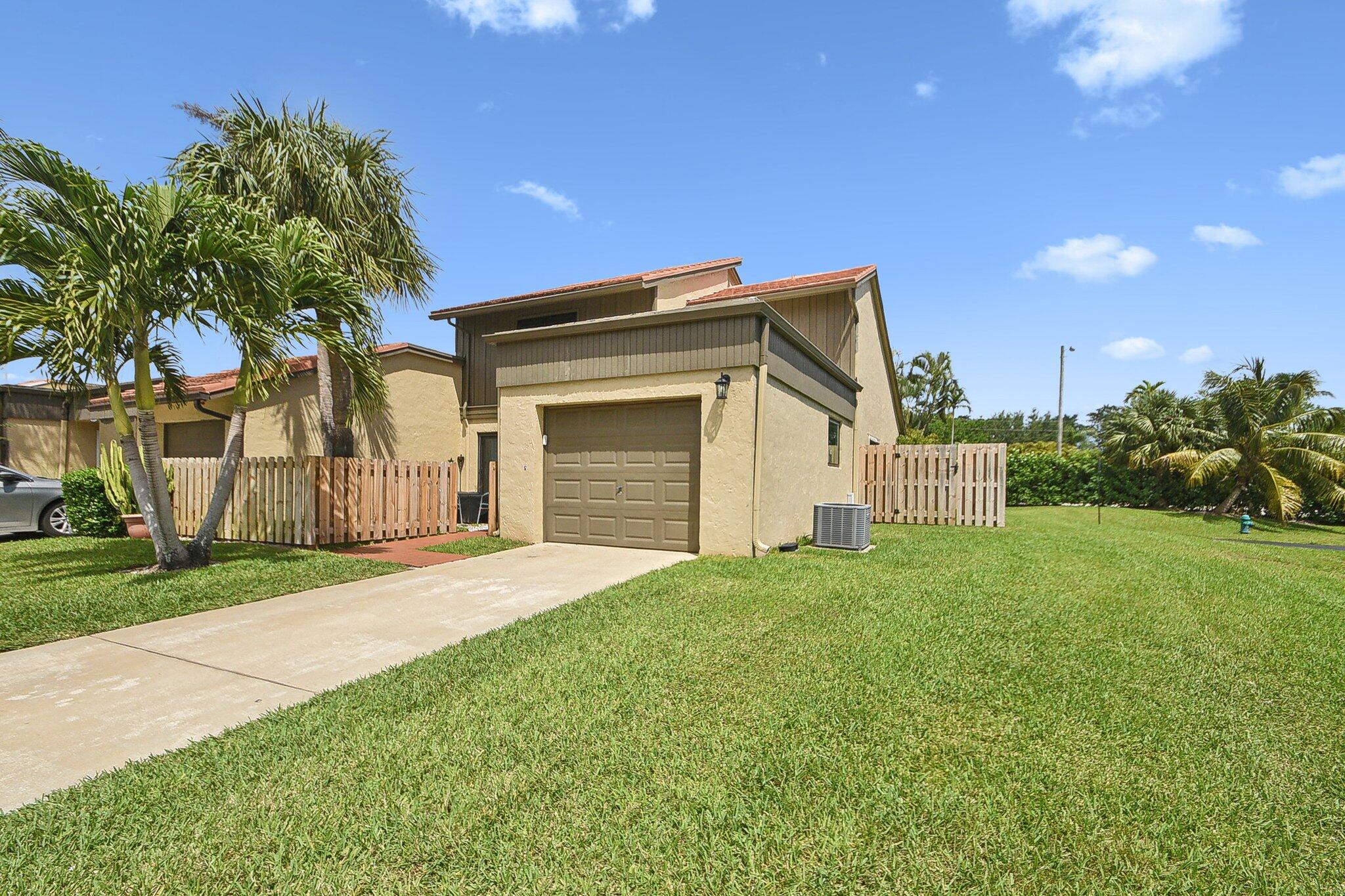 11063 Oakdale Road Boynton Beach, FL 33437 - Photo 40 of 65 a front view of a house with a yard and garage