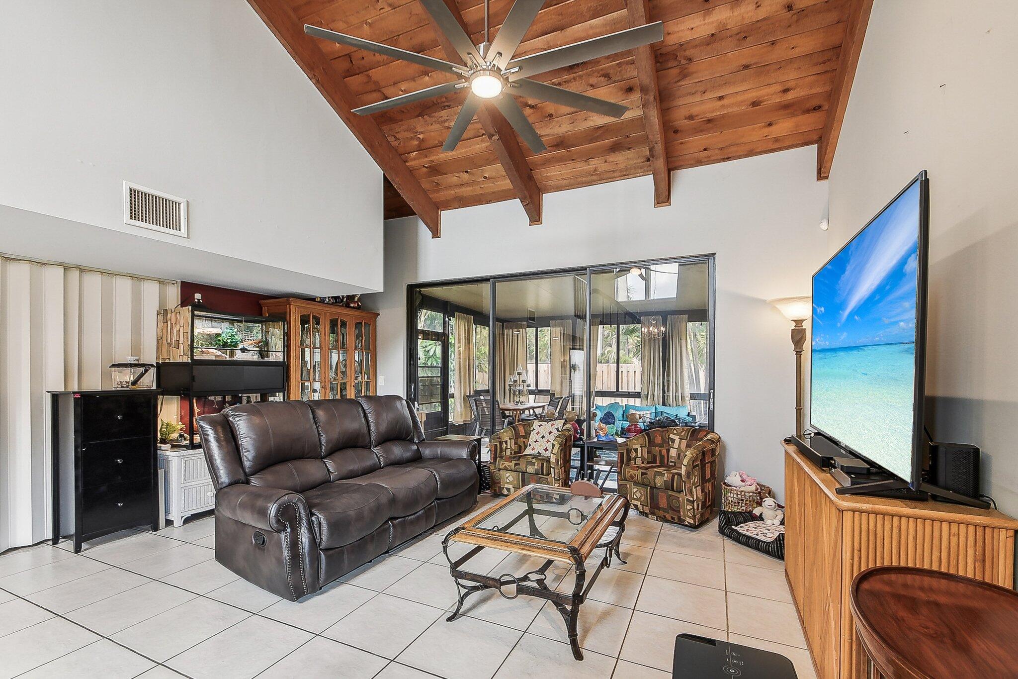 11063 Oakdale Road Boynton Beach, FL 33437 - Photo 57 of 65 a living room with furniture a flat screen tv and floor to ceiling window