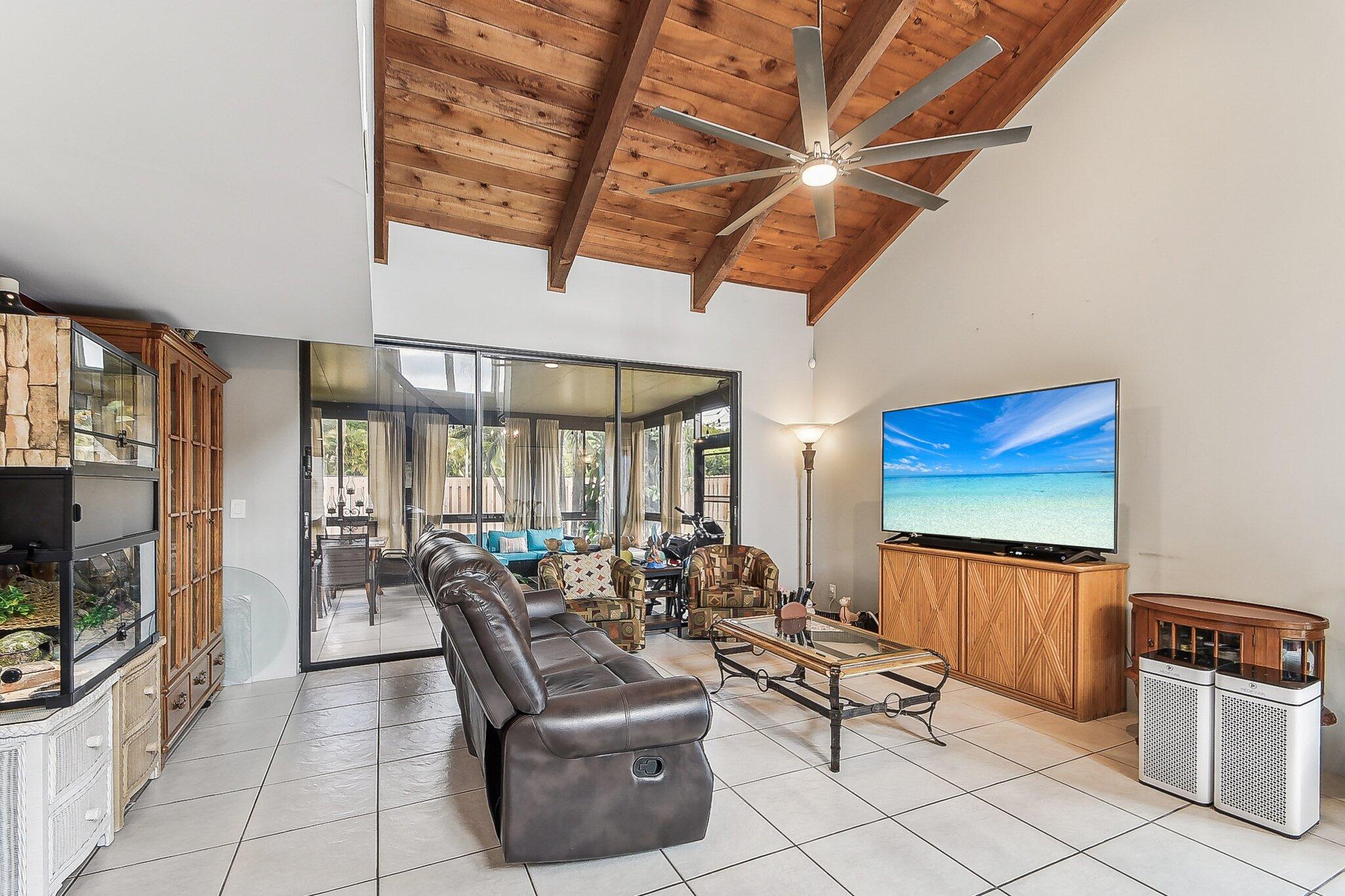 11063 Oakdale Road Boynton Beach, FL 33437 - Photo 6 of 65 a living room with furniture a flat screen tv and floor to ceiling window