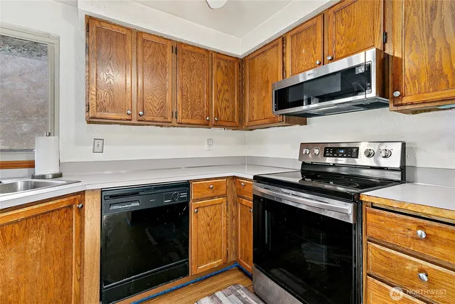 a kitchen with stainless steel appliances granite countertop a stove microwave and sink