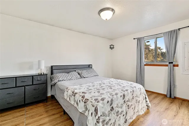 a bedroom with a bed and wooden floor
