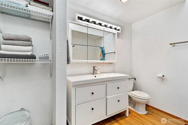 a bathroom with a granite countertop toilet a sink and a mirror
